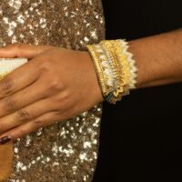 Bangle brodé à la main de fil métallisé de couleur or, perle et gris anthracite. Sequins en laiton et perles, strass, doublure en cuir souple.