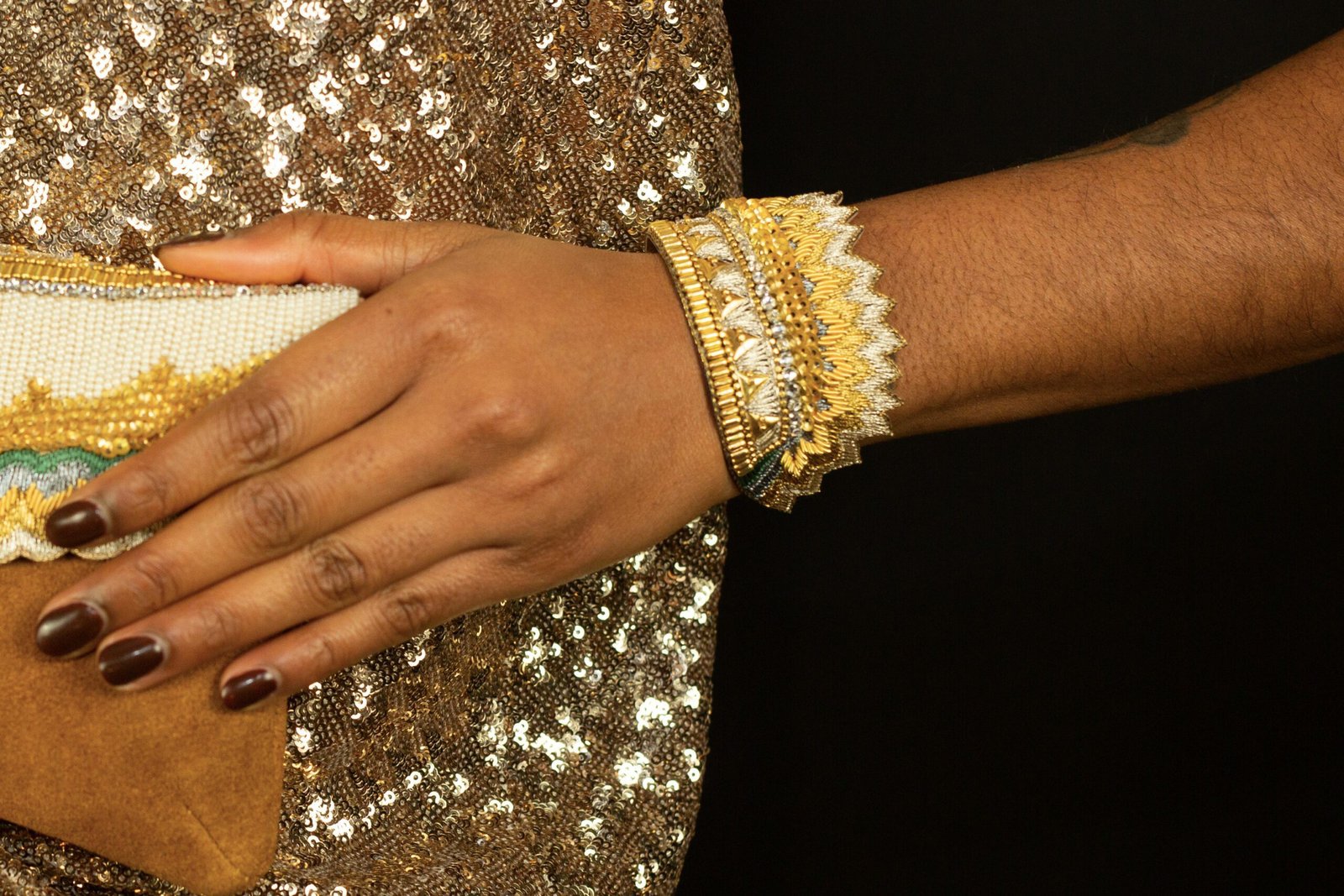 Bangle brodé à la main de fil métallisé de couleur or, perle et gris anthracite. Sequins en laiton et perles, strass, doublure en cuir souple.