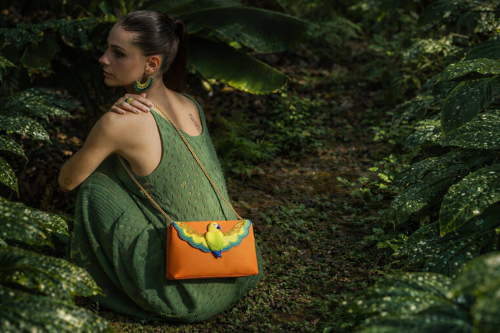 Pochette bandoulière brodée Parrot Nahua x Nach ocre portée avec tenue bohème en jungle