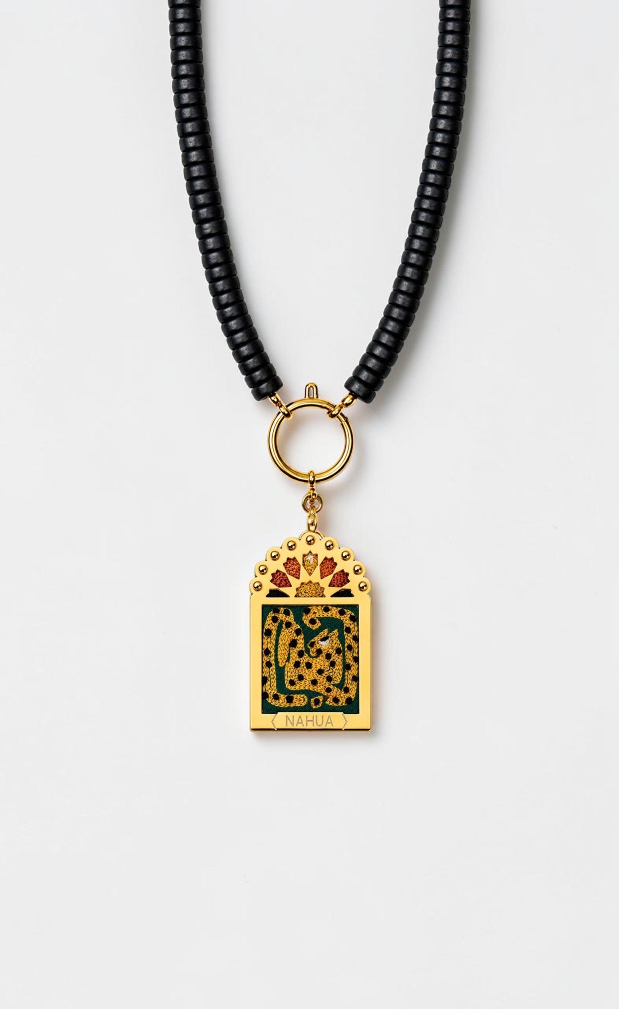 Collier Doriana de la collection Dwara par Nahua, pendentif ex-voto doré brodé représentant un léopard doré, monté sur un collier de perles noires.