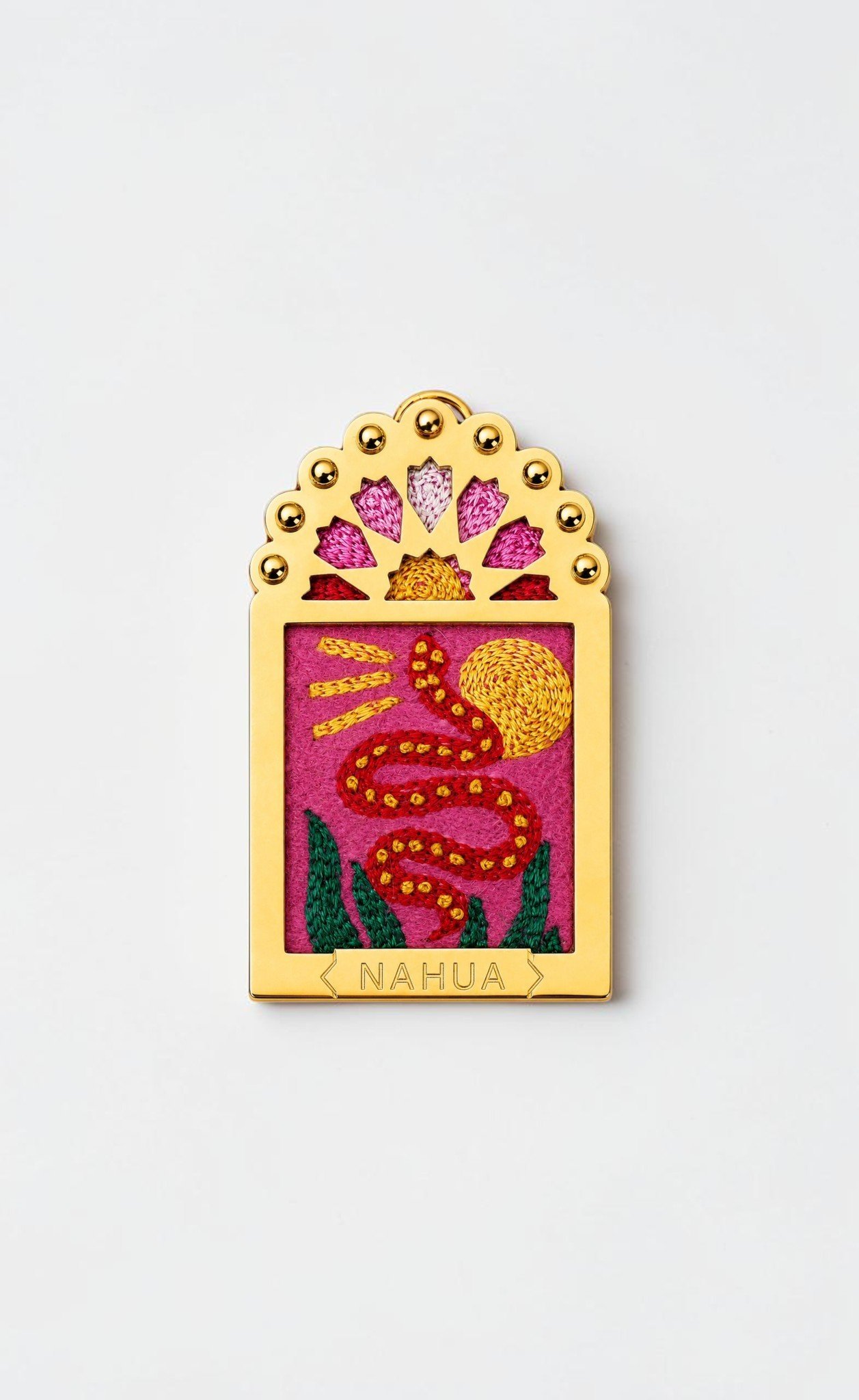 Charm Dwara Nahua en métal doré et broderie représentant un serpent rouge devant un soleil doré sur fond rose.